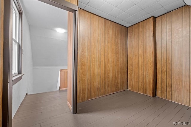 empty room with wooden walls and hardwood / wood-style floors