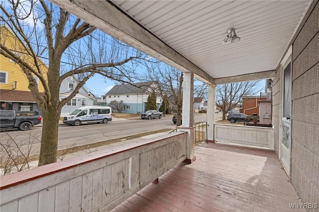 deck featuring covered porch and a residential view