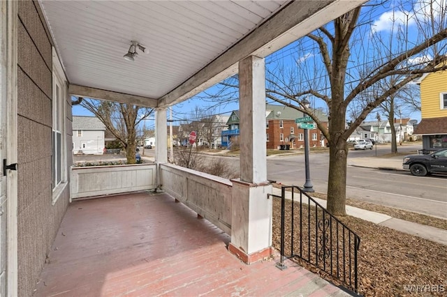 wooden terrace with covered porch and a residential view