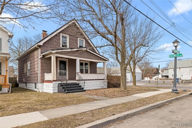 bungalow-style house with covered porch and a chimney