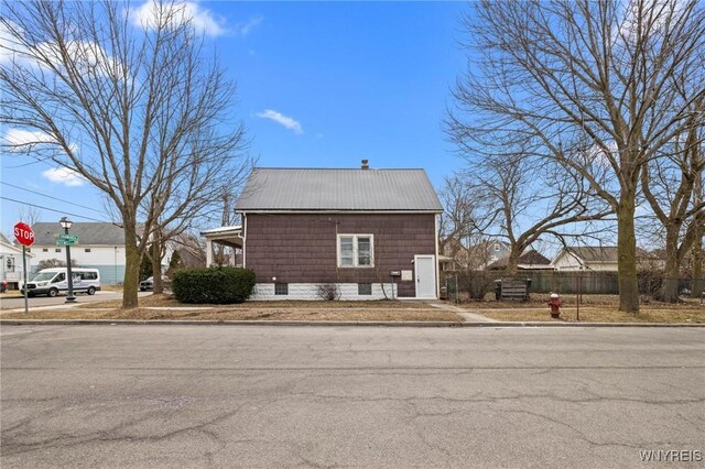 view of property exterior with fence and metal roof