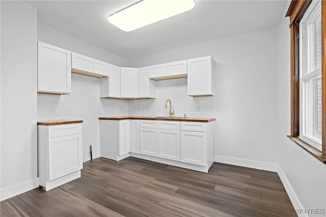 kitchen featuring dark wood finished floors, tasteful backsplash, white cabinetry, and a sink