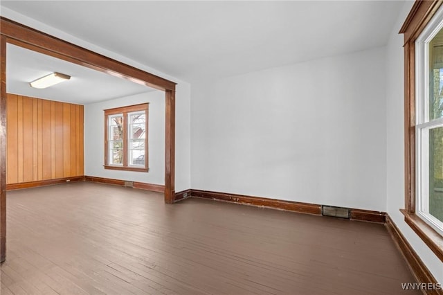 unfurnished room featuring visible vents, baseboards, and hardwood / wood-style floors