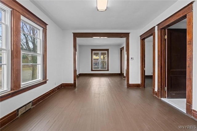 hallway with baseboards and dark wood-type flooring