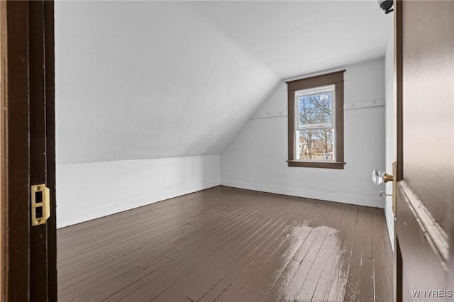 additional living space with vaulted ceiling, baseboards, and dark wood-style flooring