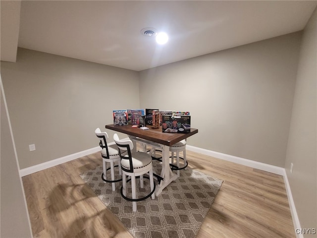 dining space with baseboards and wood finished floors