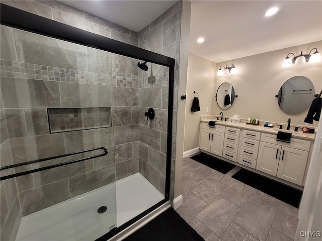 bathroom featuring a sink, a shower stall, baseboards, and double vanity