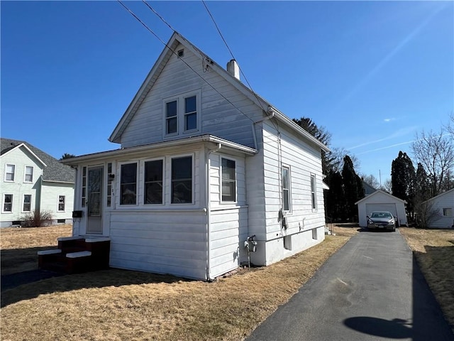 view of home's exterior with an outbuilding, entry steps, and driveway