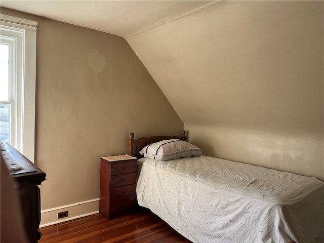 bedroom featuring dark wood-style floors, baseboards, and vaulted ceiling