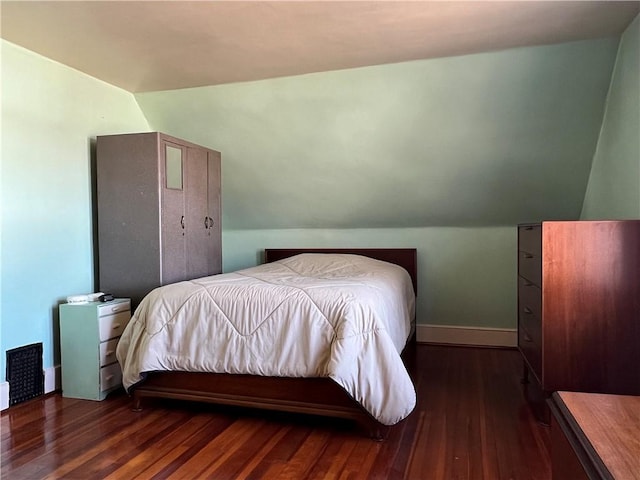 bedroom with lofted ceiling, wood finished floors, and baseboards