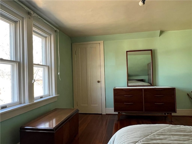 bedroom with dark wood-style floors and baseboards