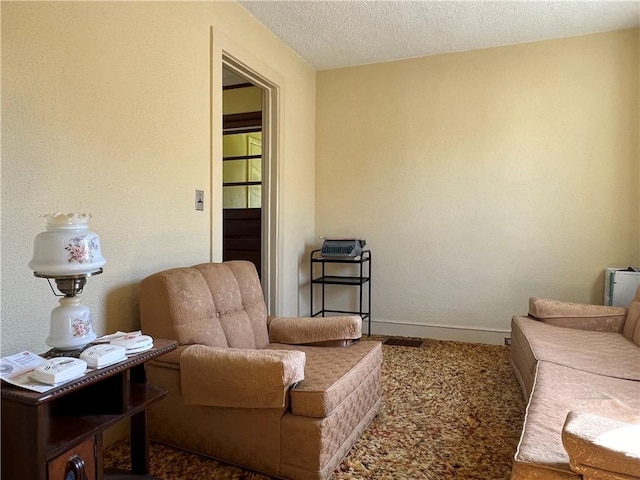 sitting room with a textured ceiling and baseboards