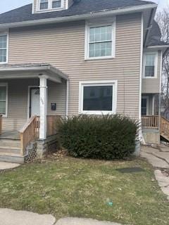 american foursquare style home featuring a front lawn