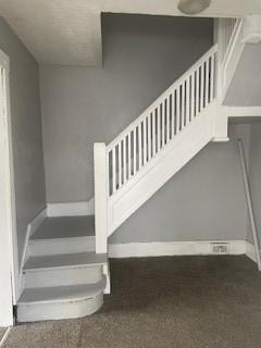 stairs with baseboards and carpet