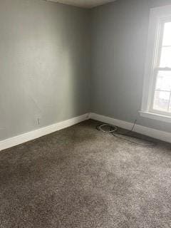 carpeted empty room with a wealth of natural light and baseboards