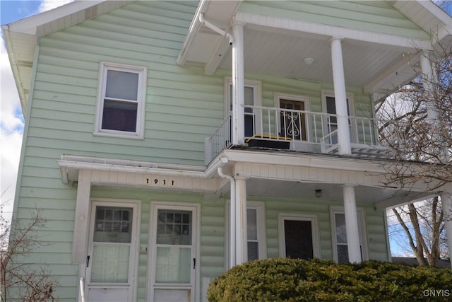 exterior space with a porch and a balcony