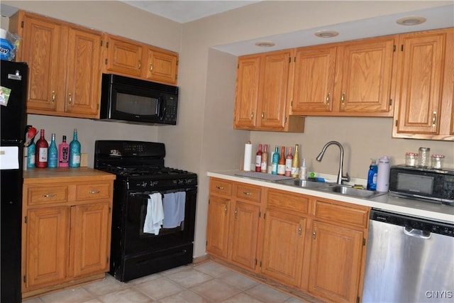 kitchen featuring black appliances, light countertops, brown cabinets, and a sink