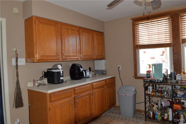 kitchen featuring brown cabinetry, plenty of natural light, light countertops, and ceiling fan