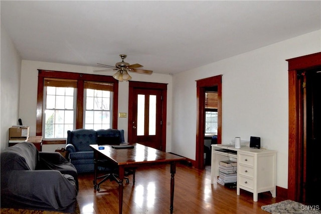 living room with a ceiling fan, dark wood-style floors, and baseboards