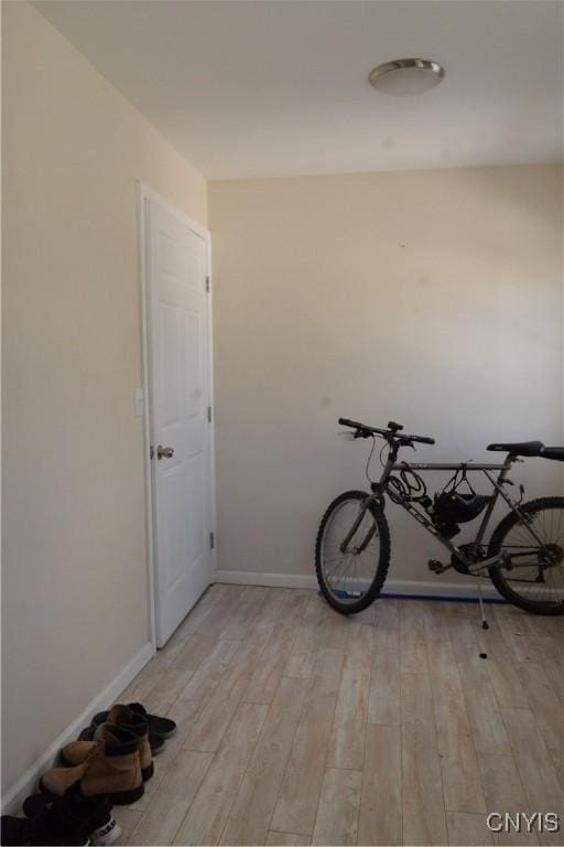 exercise area featuring baseboards and light wood-style floors