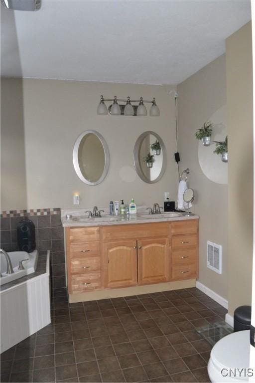 full bathroom with double vanity, a bath, visible vents, and a sink