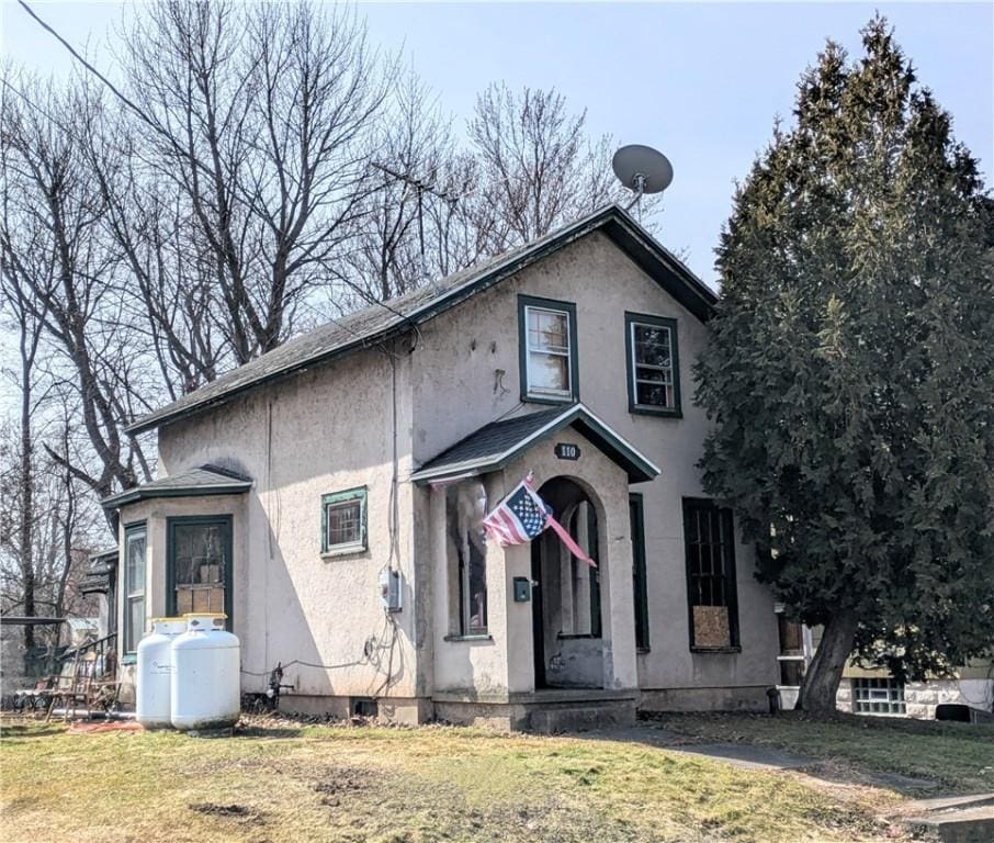 view of front of home with stucco siding and a front yard