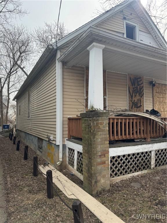 view of side of home featuring covered porch