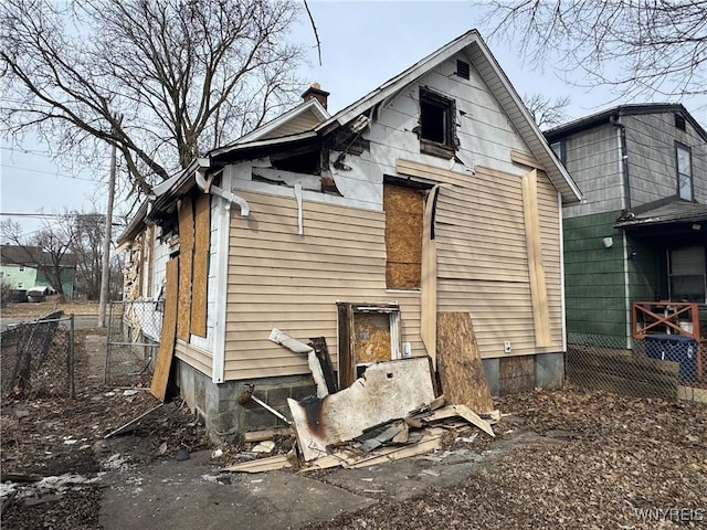 rear view of house featuring fence and a chimney