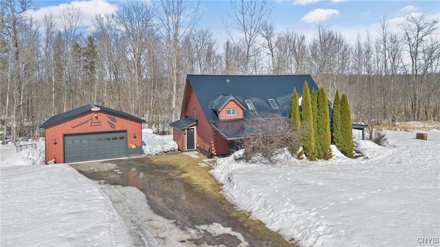 view of front of property featuring an outdoor structure, a detached garage, and metal roof