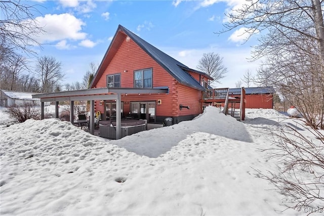 snow covered property featuring log exterior and a wooden deck