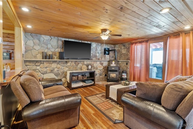 living room with wood finished floors, a ceiling fan, wooden ceiling, and a wood stove