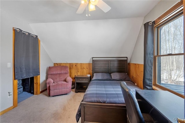 carpeted bedroom with wood walls, a ceiling fan, and vaulted ceiling