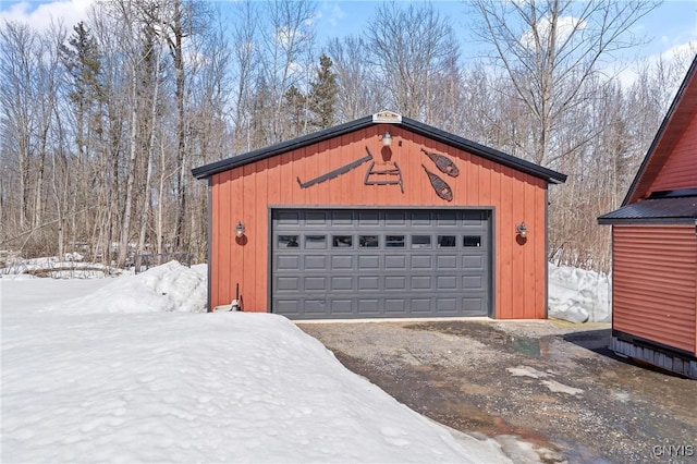 snow covered garage with a detached garage