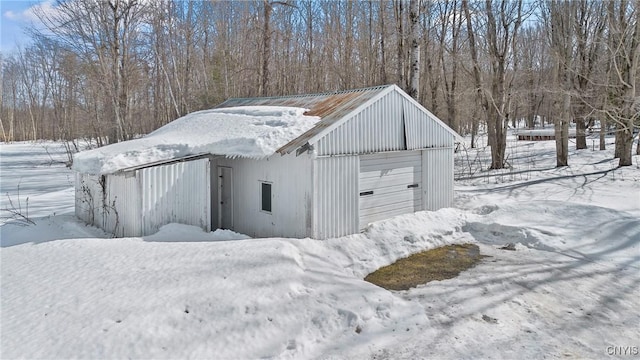 snow covered garage with a detached garage