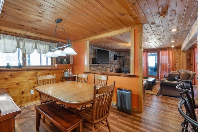 dining space with a wealth of natural light, wood walls, wooden ceiling, and wood-type flooring