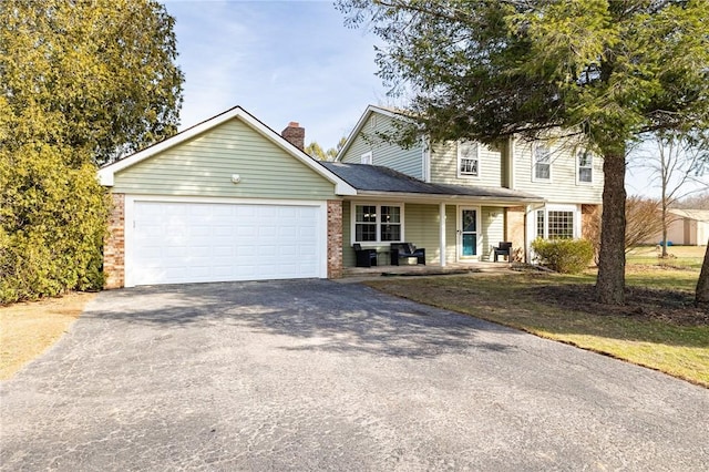 traditional home featuring brick siding, driveway, a chimney, and a garage