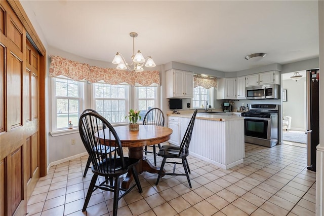 dining area with an inviting chandelier, light tile patterned floors, and baseboards