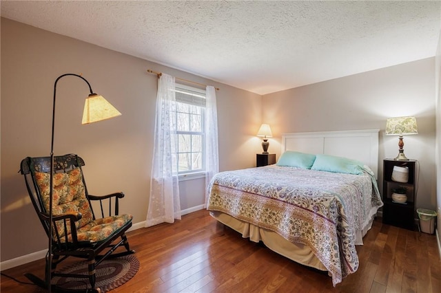 bedroom with baseboards, a textured ceiling, and hardwood / wood-style floors