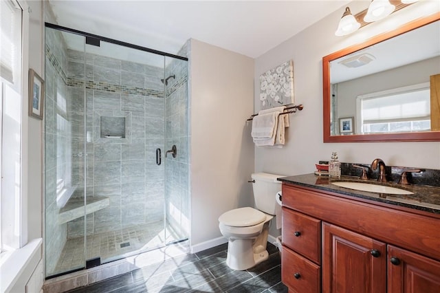 full bath with a shower stall, toilet, vanity, and baseboards