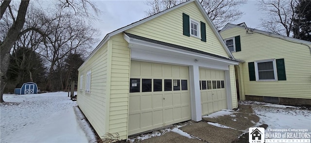 snow covered garage featuring a garage