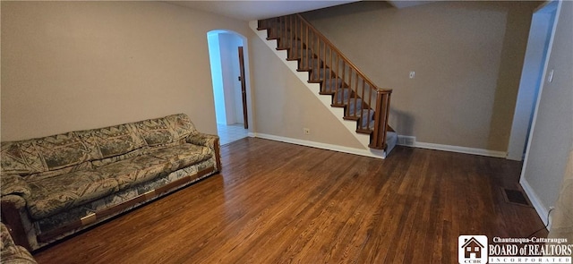1620 Haskell Rd, Portville, NY 14760 - unfurnished living room featuring arched walkways, stairs, baseboards, and wood finished floors