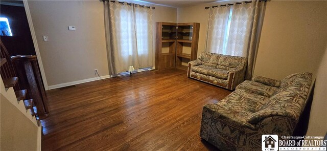 living area featuring visible vents, wood finished floors, and baseboards