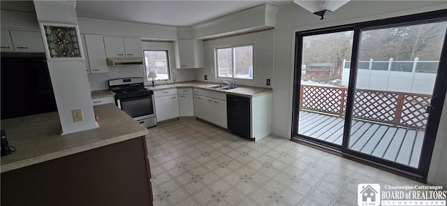 kitchen featuring under cabinet range hood, light floors, light countertops, black dishwasher, and range with gas stovetop