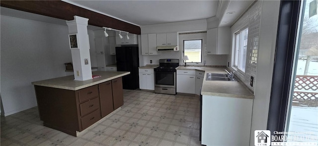 kitchen with light floors, exhaust hood, stainless steel range, white cabinetry, and a sink