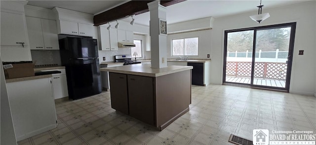 kitchen with under cabinet range hood, a kitchen island, light floors, and black appliances