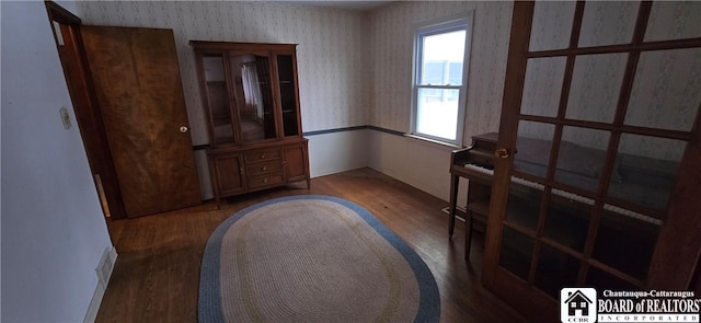 interior space with visible vents, wood finished floors, and wallpapered walls