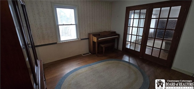 sitting room featuring visible vents, french doors, wallpapered walls, and wood finished floors