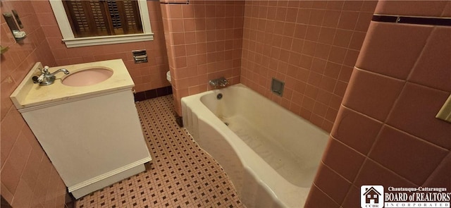 full bathroom with vanity, tile walls, toilet, and tile patterned floors