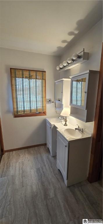 bathroom with baseboards, wood finished floors, and vanity