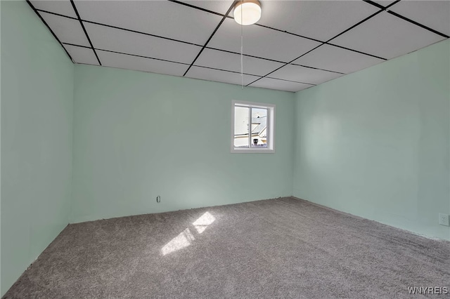 carpeted empty room with a paneled ceiling